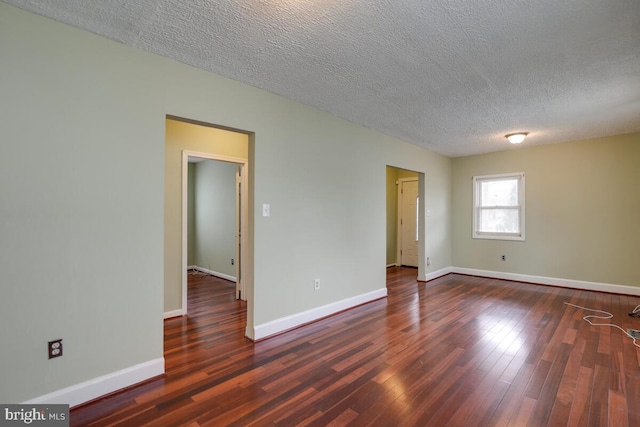 spare room with dark hardwood / wood-style flooring and a textured ceiling