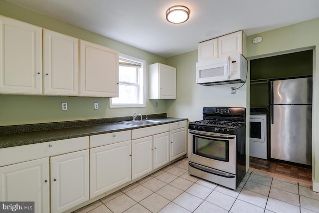 kitchen with washer / dryer, sink, light tile patterned floors, stainless steel appliances, and white cabinets