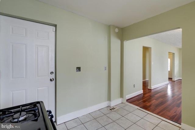 spare room with a textured ceiling and light tile patterned flooring