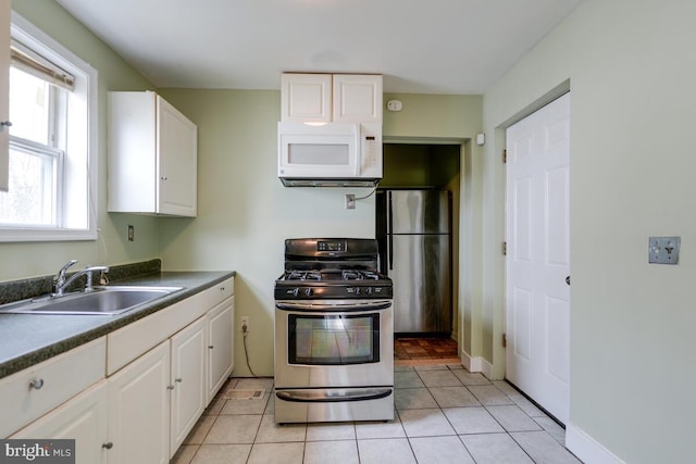 kitchen featuring stainless steel appliances, white cabinetry, sink, and light tile patterned floors