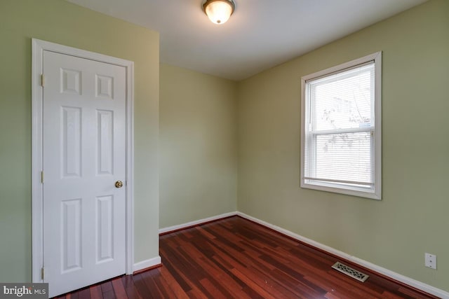 unfurnished room featuring dark wood-type flooring