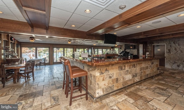 bar with a drop ceiling and ceiling fan