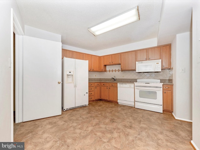 kitchen with tasteful backsplash, sink, white appliances, and a textured ceiling