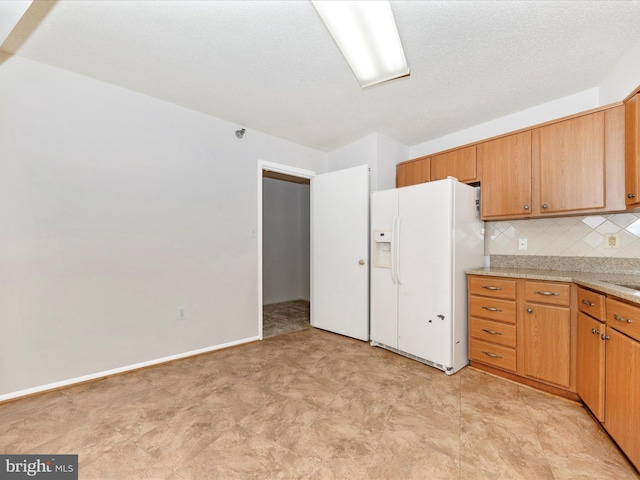 kitchen with white fridge with ice dispenser, backsplash, and a textured ceiling