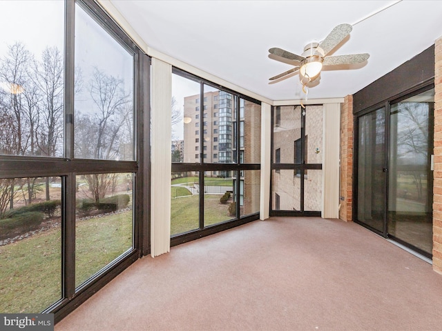 unfurnished sunroom featuring ceiling fan