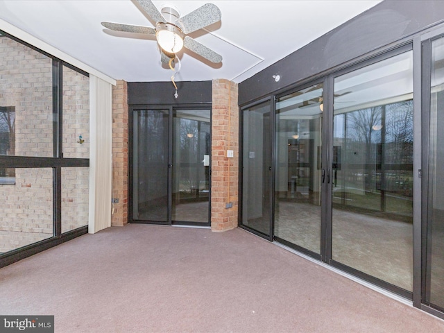 unfurnished sunroom featuring ceiling fan