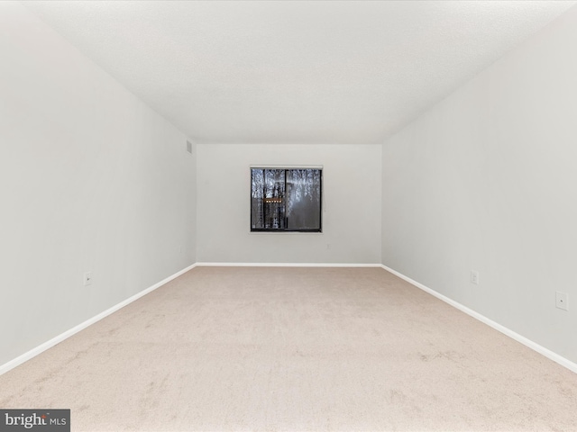 unfurnished room featuring carpet and a textured ceiling