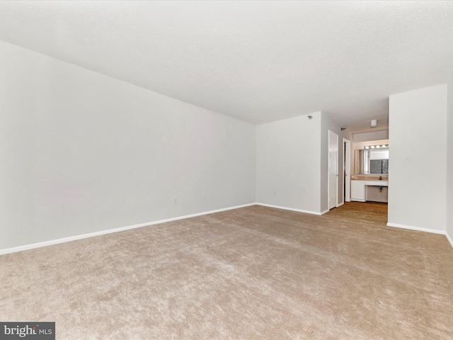 unfurnished living room featuring light carpet and a textured ceiling