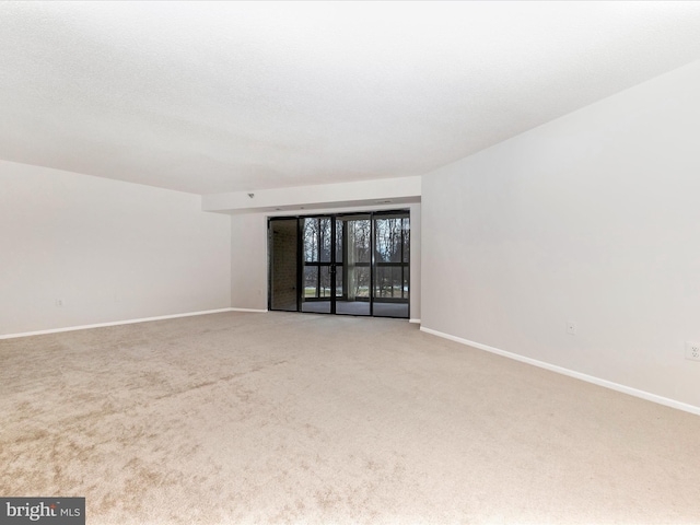 empty room with carpet floors and a textured ceiling