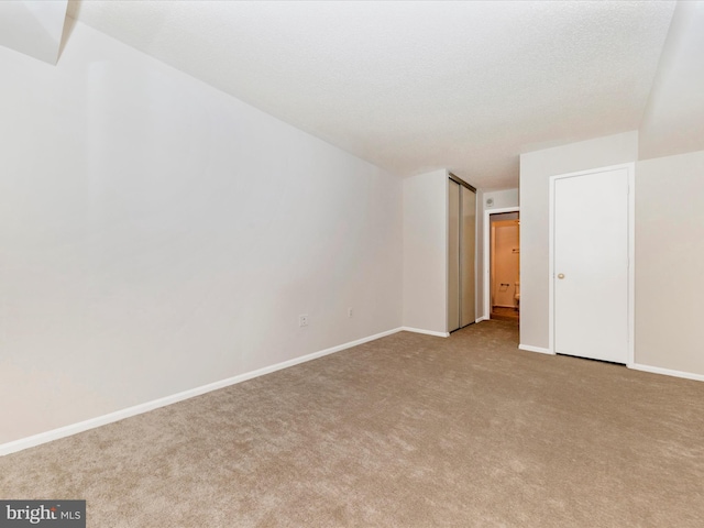 unfurnished bedroom featuring light colored carpet and a textured ceiling