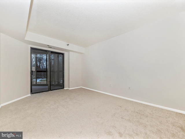 carpeted empty room with a textured ceiling