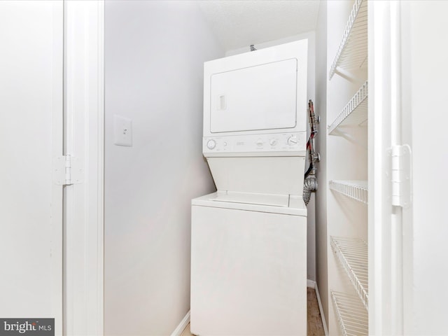 washroom featuring stacked washer and dryer and a textured ceiling