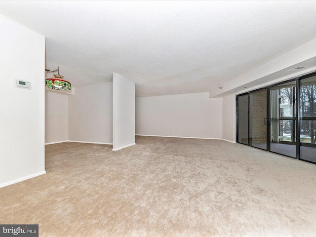 unfurnished living room featuring light carpet and a textured ceiling