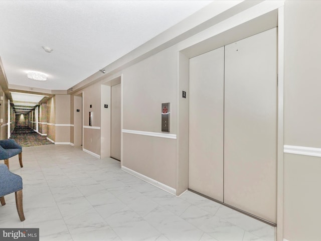 hall featuring elevator and a textured ceiling