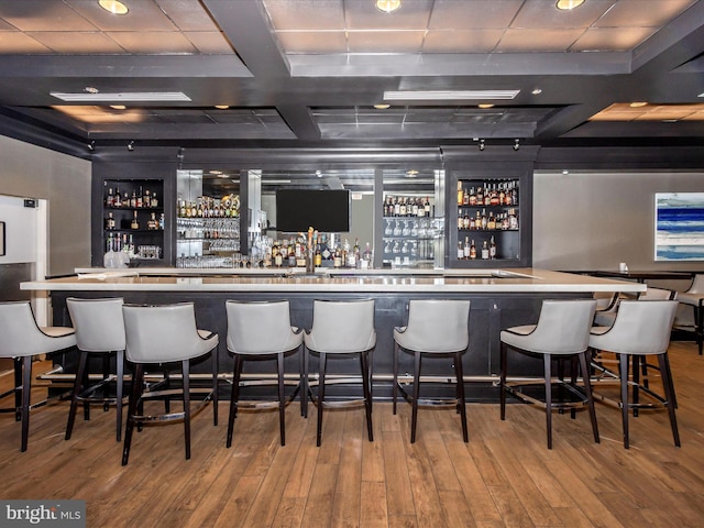 bar featuring coffered ceiling, wood-type flooring, and beamed ceiling