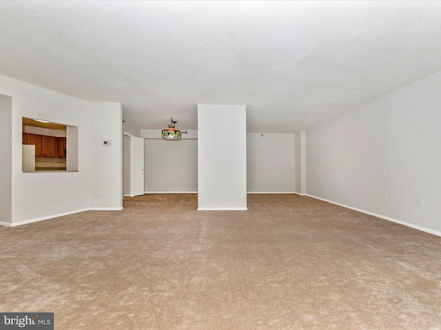 unfurnished living room with light colored carpet and a textured ceiling