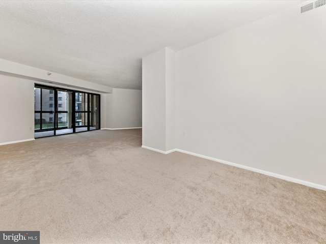 carpeted spare room with a textured ceiling