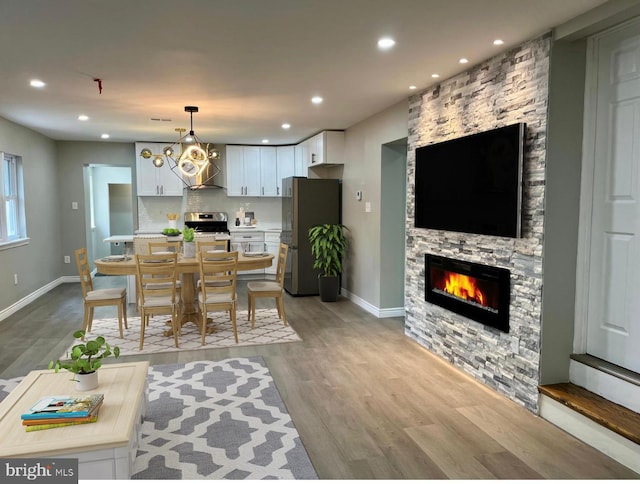 interior space with a stone fireplace and light hardwood / wood-style flooring