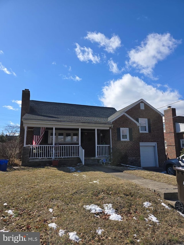 ranch-style home featuring brick siding, a chimney, an attached garage, covered porch, and a front yard