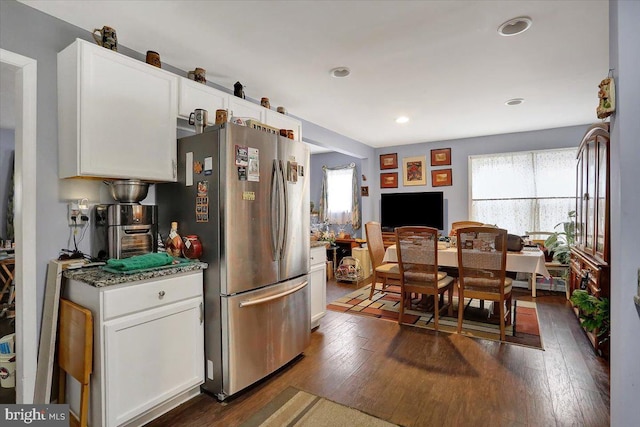 kitchen featuring recessed lighting, white cabinetry, freestanding refrigerator, dark stone countertops, and dark wood finished floors