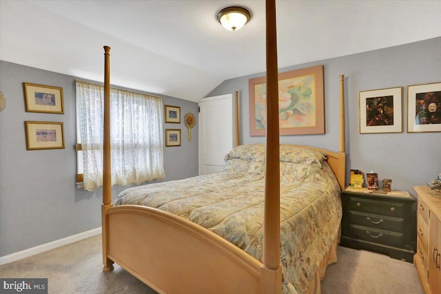 bedroom featuring light carpet, lofted ceiling, and baseboards