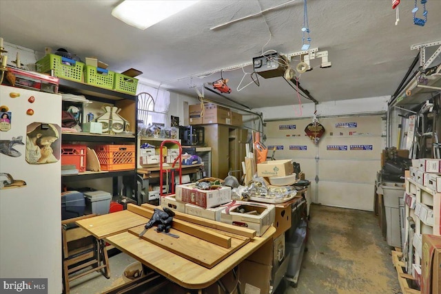 garage with a garage door opener, a workshop area, and freestanding refrigerator