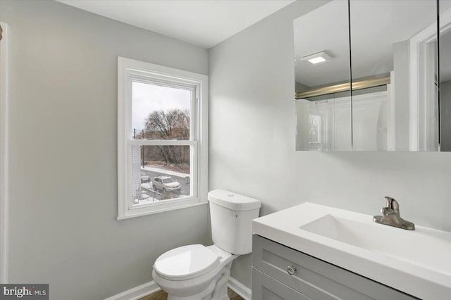 bathroom with vanity, toilet, and a shower with shower door