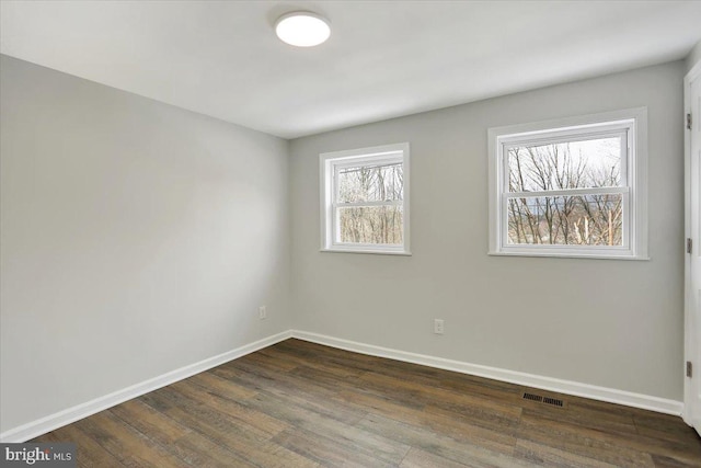 unfurnished room with dark wood-type flooring