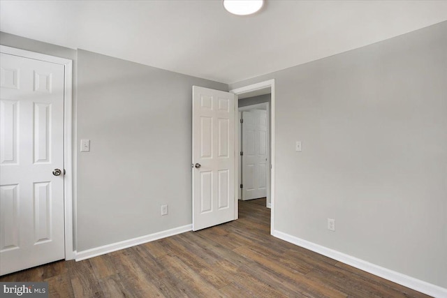 unfurnished bedroom with dark hardwood / wood-style floors