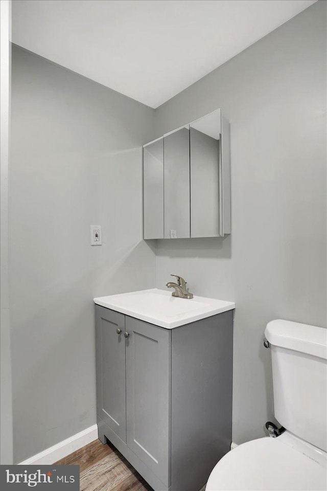 bathroom featuring hardwood / wood-style flooring, vanity, and toilet