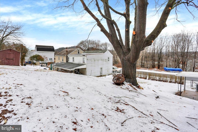 yard layered in snow with a storage shed