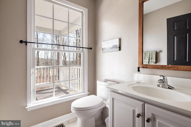 bathroom featuring vanity, a wealth of natural light, and toilet