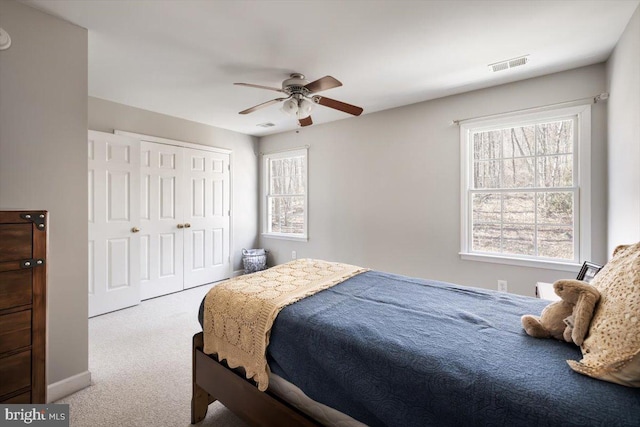 carpeted bedroom featuring ceiling fan and a closet