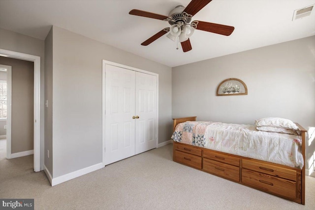 bedroom featuring light carpet, a closet, and ceiling fan