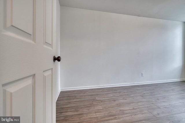 empty room with baseboards and wood finished floors