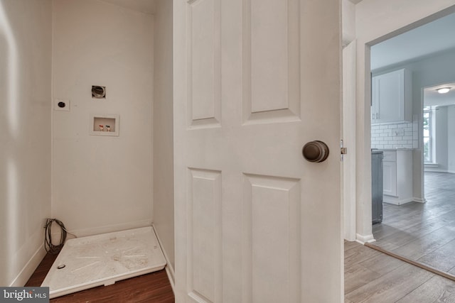 interior space featuring baseboards, hookup for a washing machine, electric dryer hookup, and light wood-style floors