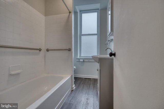 full bath featuring plenty of natural light, wood finished floors, toilet, and baseboards