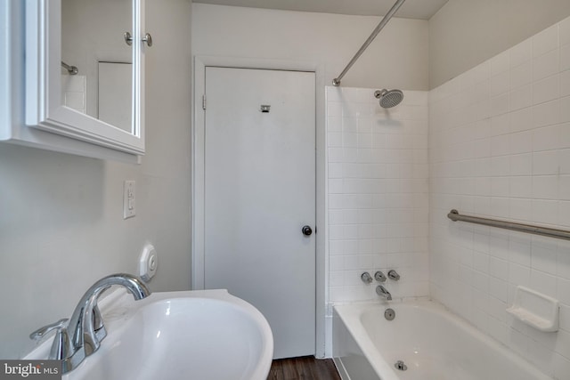 full bathroom with wood finished floors, shower / bathing tub combination, and a sink