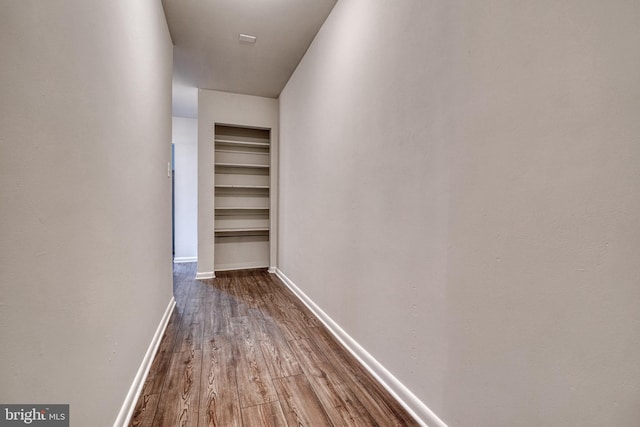 hall featuring wood finished floors and baseboards