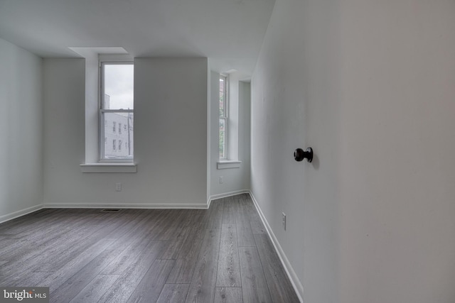 empty room featuring dark wood-style floors and baseboards