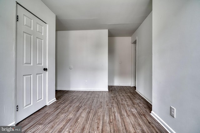 empty room with baseboards and wood finished floors