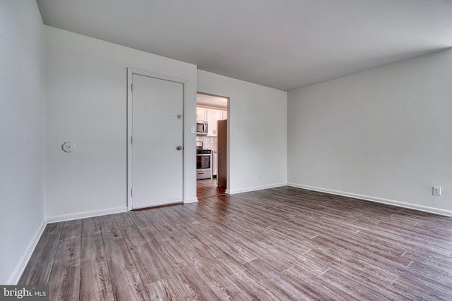 empty room with baseboards and wood finished floors