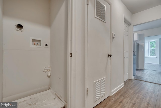 interior space featuring laundry area, light wood finished floors, hookup for a washing machine, and visible vents