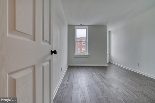 spare room featuring wood finished floors and baseboards