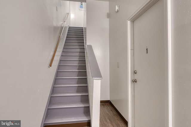 staircase with baseboards and wood finished floors