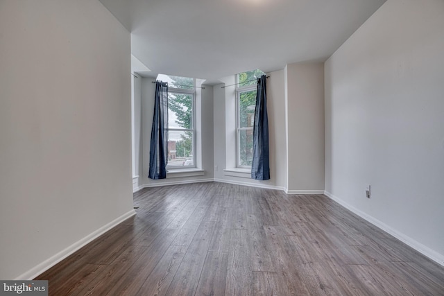 spare room with wood finished floors and baseboards