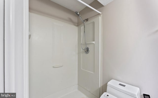 full bath with a stall shower and toilet