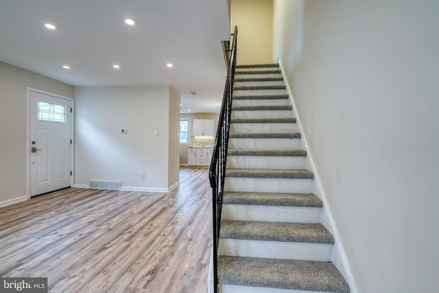 staircase featuring hardwood / wood-style flooring and a healthy amount of sunlight