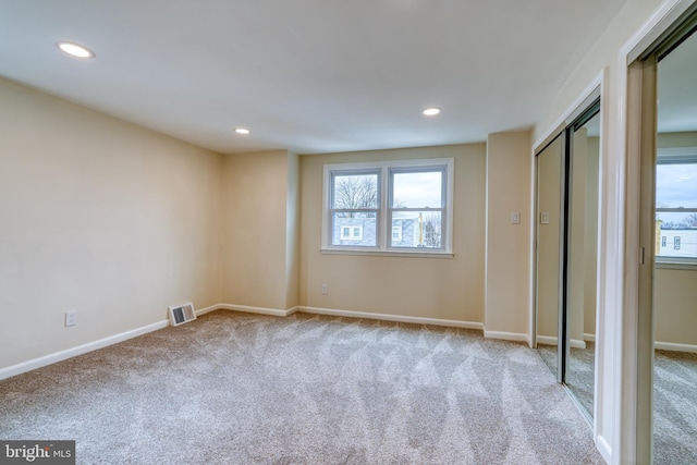 unfurnished bedroom featuring light carpet