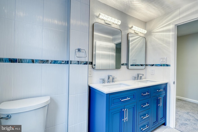 bathroom with vanity, tile walls, and toilet